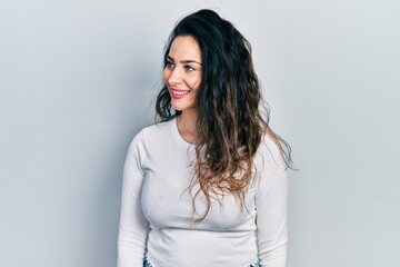 Young hispanic woman wearing casual clothes looking to side, relax profile pose with natural face and confident smile.