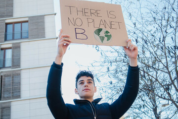 Arab teenager with climate change banner on environment demonstration