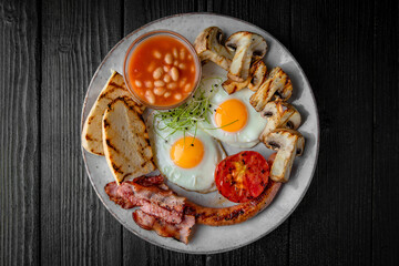 Classic English Breakfast of fried eggs, toast, cheese, bacon, tomatoes. Healthy Nutritious Dish with food top view.