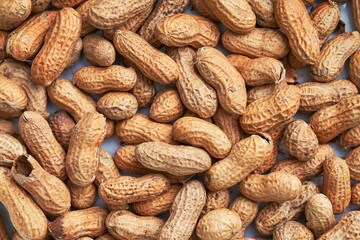 Fototapeta premium Healthy roasted unpeeled peanuts. Brown nuts texture