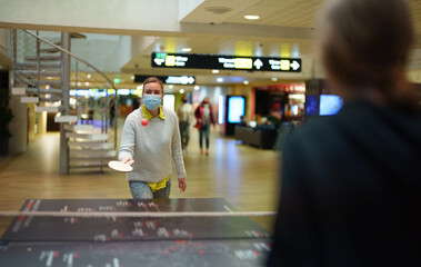 Woman plays table tennis at the airport while she waits for a flight.