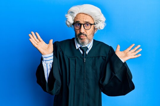 Middle age hispanic man wearing judge uniform clueless and confused with open arms, no idea and doubtful face.