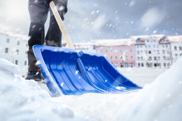 Snow removal with a snow shovel in winter - obrazy, fototapety, plakaty