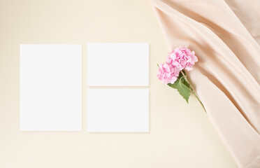Mockup wedding invitation with pink hydrangea flowers on the beige background
