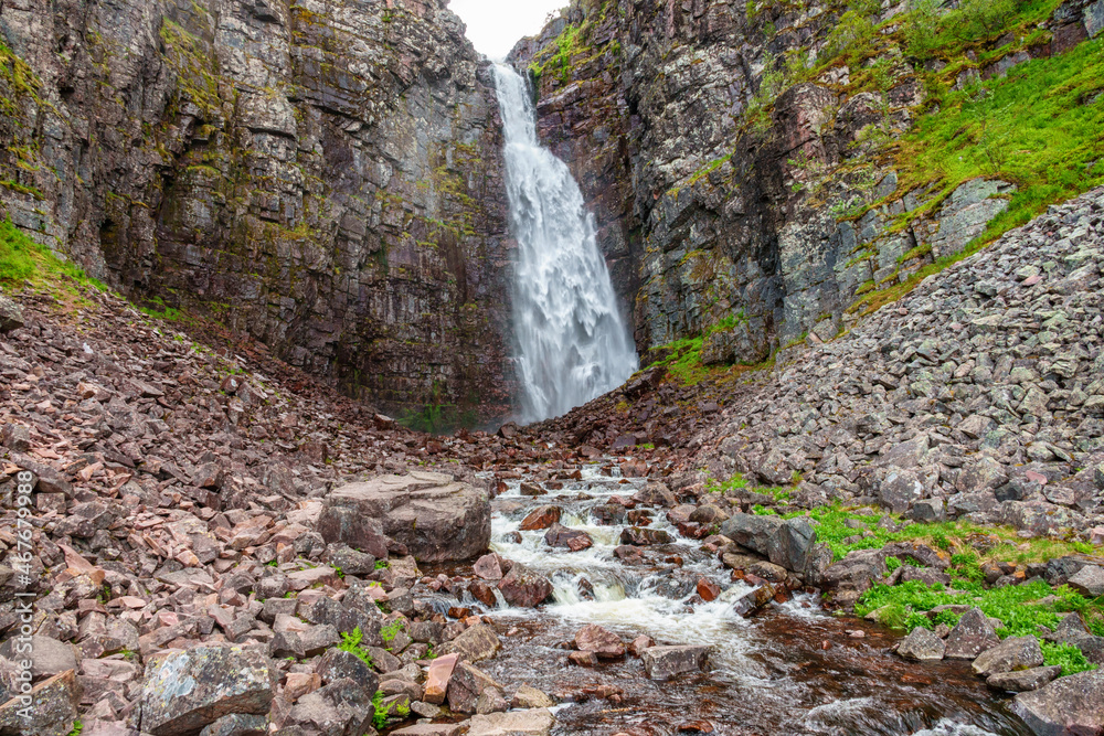 Wall mural High waterfall in a beautiful rocky landscape