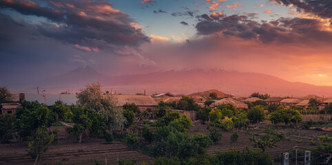 View from the village with fruit and vegetable gardens to the gorgeous sunset over Mount Ararat in Armenia. Travel and agriculture concept