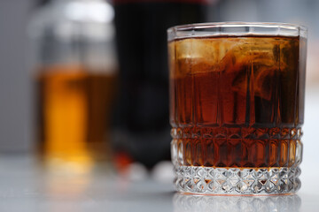 Full glass of alcoholic drink with ice on the table