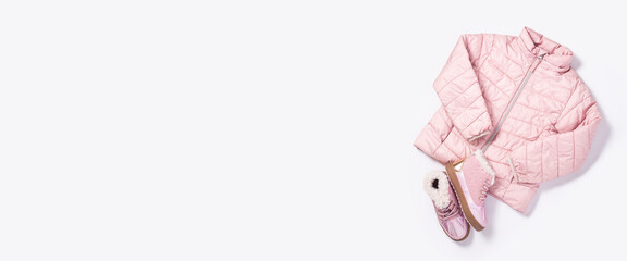 Baby jacket and boots for a girl on a white background. Top view, flat lay. Banner. © Alex