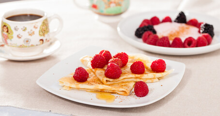 breakfast of pancakes with fresh raspberries on table