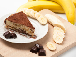 Sweet dessert. A piece of banana cake with marshmallows, pieces of a dark chocolate and banana slices