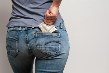 woman pulling a hundred dollar bill out of the back pocket of her pants