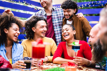 Multicultural people having genuine fun moment at fancy cocktail bar patio - Beverage life style concept with people laughing together on happy hour at sidewalk restaurant cafe - Bright vivid filter