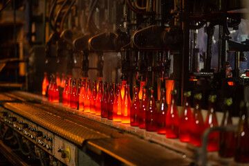 Glass factory, industrial production of glass containers. Modern technology, robots machines make...