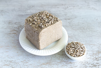 halva from sunflower seeds on a white plate. national traditional sweetness of turkish halva on the table. High quality photo