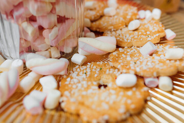  decor of small pastry shop on plate there are cookies sprinkled with sugar sprinkles around there are small marshmallows. the concept of a small business.