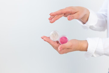 Female hands holding face powder on a white background. Isolated background. Space for text