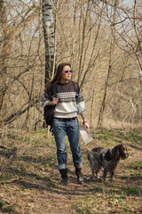 Beautiful woman and brown cocker spaniel in the forest