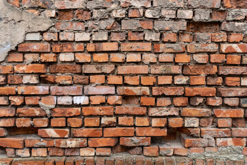 Old and damaged brick wall background with dropped out  bricks.