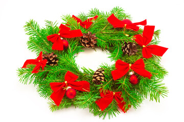 Traditional Christmas holiday wreath from green fir tree branch decorated with red ball, knot and pine cone isolated on white background. Winter holiday background