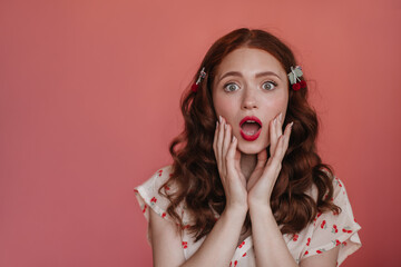 Close-up portrait of shocked caucasian young girl with open mouth on isolated background. Auburn-haired female wearing white blouse depicts surprise at what she saw. Impression emotion concept.