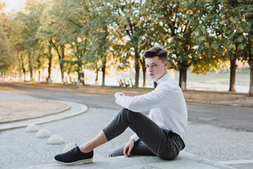 A student in a shirt with a sweater and a bow tie looks into the future.