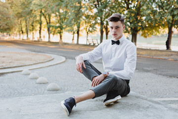 Obraz premium A student in a shirt with a sweater and a bow tie looks into the future.