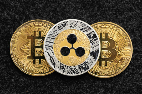 Ripple cryptocurrency coin laying on top of two bitcoin