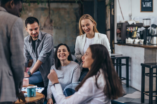 People in office talking during informal meeting.