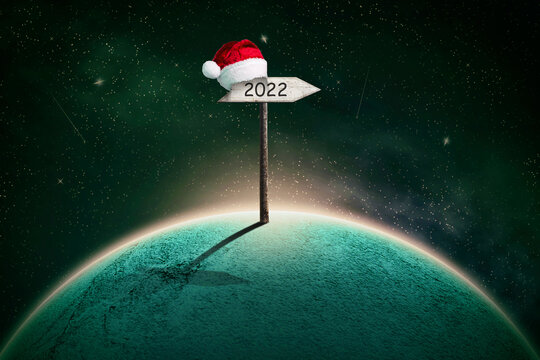Abstract Christmas background, with a planet in the cosmic sky, and 2022 wooden signs. Abstract festive background.