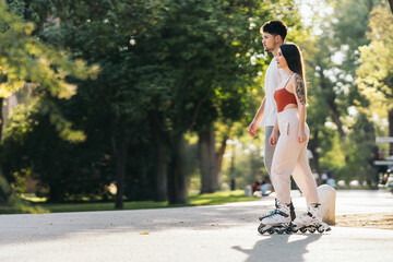 Rays of the sun illuminating two people skating in a park