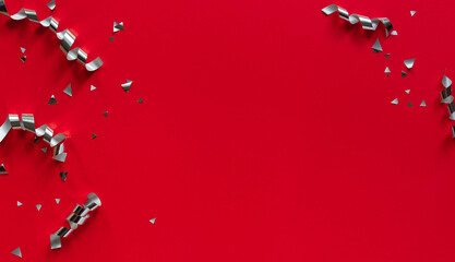 close up on group of silver color of rolling ribbon and confetti on red background with copy space for merry christmas, happy new year ,festival ,birthday and anniversary, concept design
