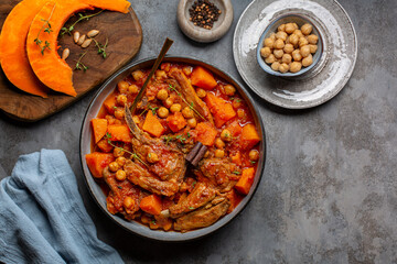 Pumpkin, lamb and chickpea stew with cinnamon sticks. Gray table surface, top view.