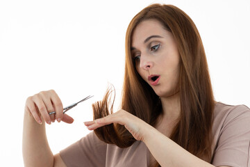 Middle-aged woman looking at split ends in surprise