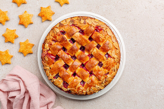 Christmas cake and cookies. Cake with cranberry jam and almonds, lattice design on top. Homemade. Top view.