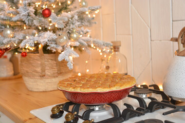 Christmas white kitchen in the Scandinavian style. Christmas decorations. Breakfast, Christmas traditions, pie, tree