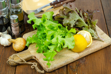 lettuce leaves on wooden cutting board, set of spices for cooking. Studio Photo.