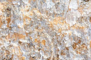 background of old plaster wall with peeling colors in white and orange