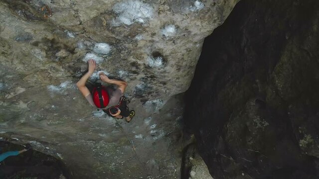 Climber falling down after failed attemp to climb steep wall of rocky mountain. Sportsman overcoming difficult route. Engaging in extreme sports and rock climbing hobby concept