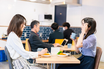 オフィスのカフェテリアのランチを食べる社員
