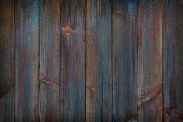 fragment of a fence made of old wooden boards with remnants of paint and nails, natural texture
