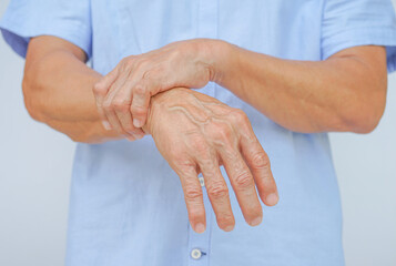 an old man support his arms which pain,numbness,weakness,paralysis concept of Guillain barre...