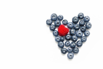 Delicious blueberries formed into a heart shape on white background.