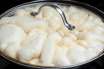 Raw dough of kaiserschmarrn during cooking in a metal pan on the oven