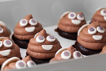 Set of cupcakes in the white gift box. Chocolate cupcake with brown cream cheese top decorated with...