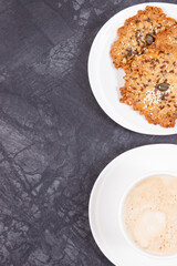 Cup of coffee with milk and fresh baked healthy oatmeal cookies. Delicious crunchy dessert. Place for text or inscription