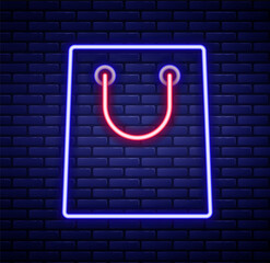 Glowing neon line Paper shopping bag icon isolated on brick wall background. Package sign. Colorful outline concept. Vector