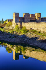 Medieval castle and wall with its reflection in the river that passes next to it. Buitrago del Lozoya, Madrid.