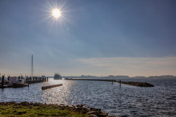 Raddampfer fährt in den sonnenbestrahlten Hafen von Maasholm im Oktober 2021