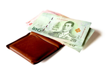 Several Thai banknotes in a brown wallet placed on a white background.