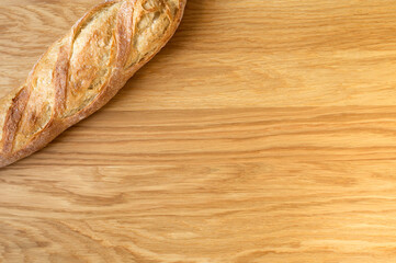 Fresh french baguette on wooden background, crispy bread. Top view, copyspace. Bakery concept.